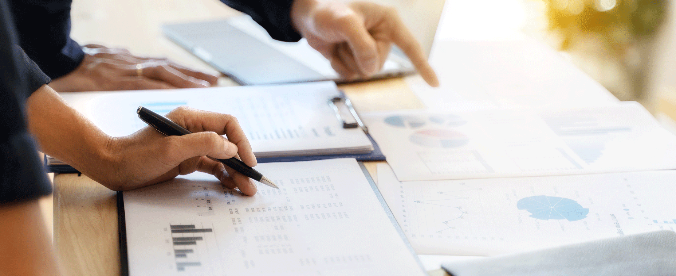 hands writing over report papers