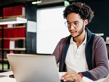 Man implements zero trust while sitting at work desk with laptop