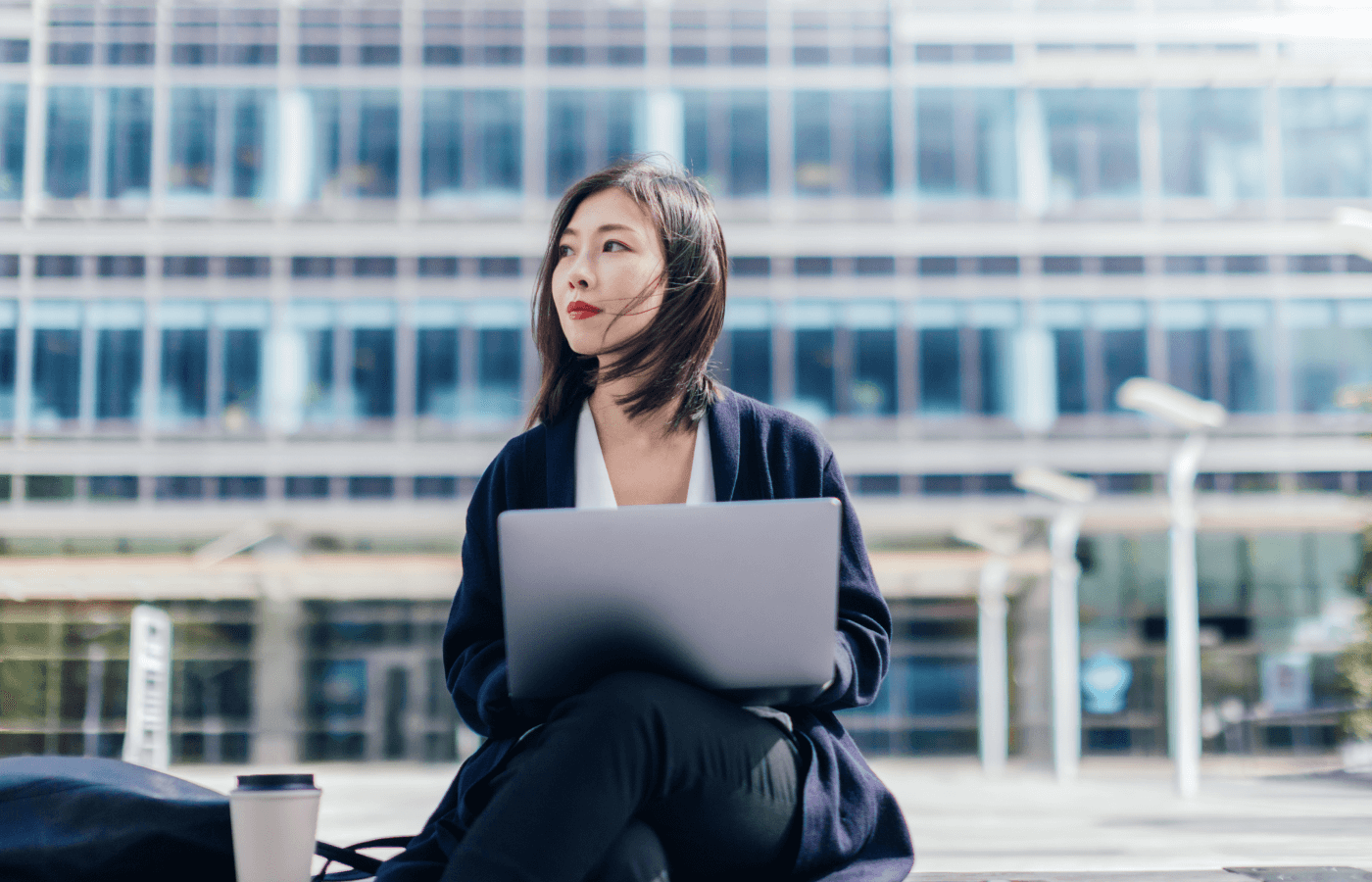 Woman on working on a bench with a laptop