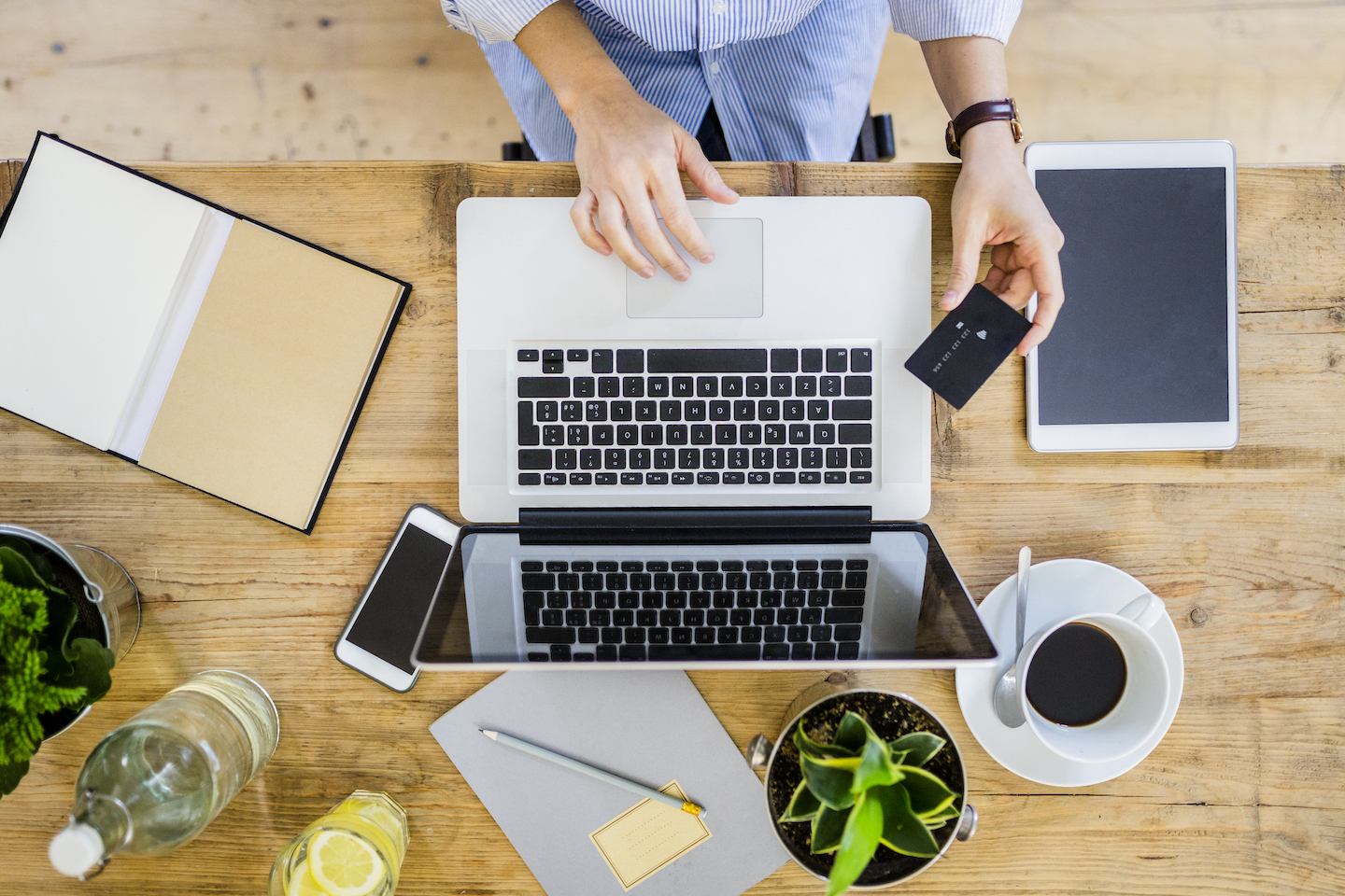 Person holding credit card and using laptop