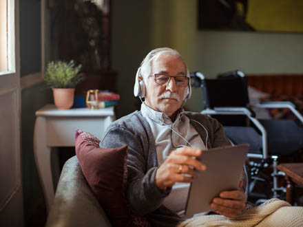 Man listening to recording on a tablet